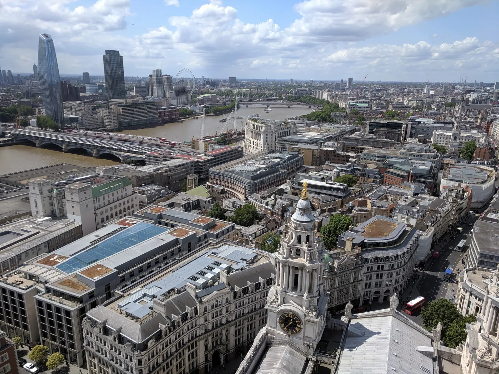 View from the Golden Gallery of St Paul's Cathedral looking west over the Thames, Blackfriars Bridge, and the London Eye, with one of the cathedral's baroque clock towers in the foreground